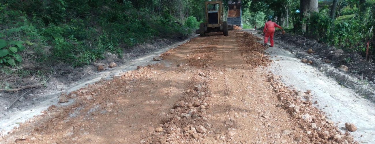 maquinarias lanzando grava y tierra para nivelar el camino