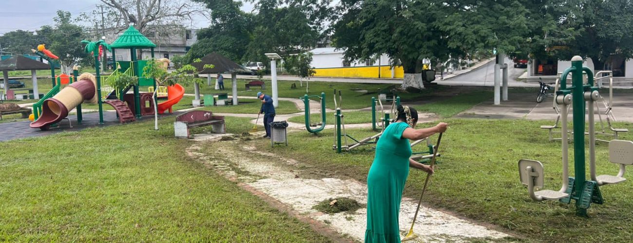 personas barriendo el parque belen